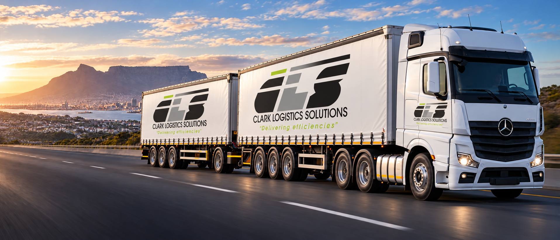 Clark Logistics Solutions truck pulling two branded trailers on a Cape Town highway at sunrise